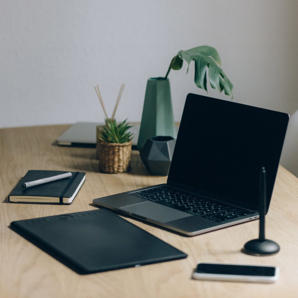 Black Laptop Computer On Brown Wooden Table. Digital product dropshipping